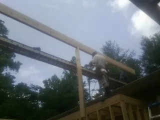 Carpenter setting a ridge beam over a new addition frame — Ice Dam Removal by Roofing Brothers in Clarinda