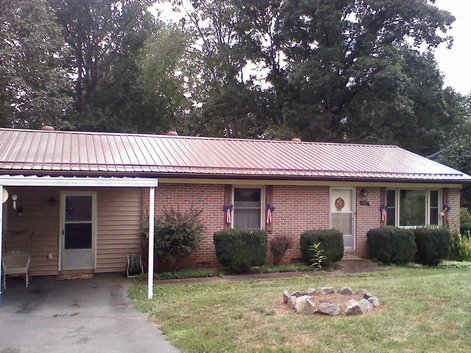 Bronze metal roof and carport on a brick ranch home — Roof Repair work by our crew in Clarinda